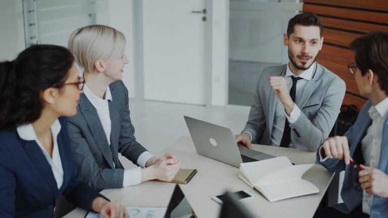 Business team reviewing market data and charts on a laptop during a planning meeting
