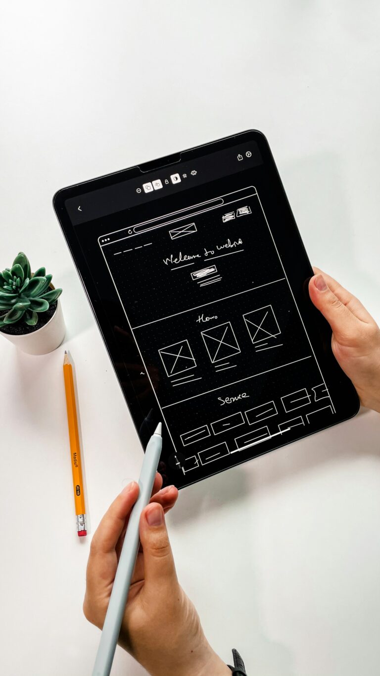 Designer sketching a website wireframe by hand on an iPad