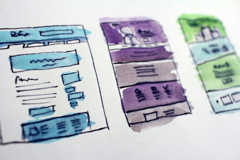 Hand-drawn watercolor wireframe sketches of several website page layouts side by side