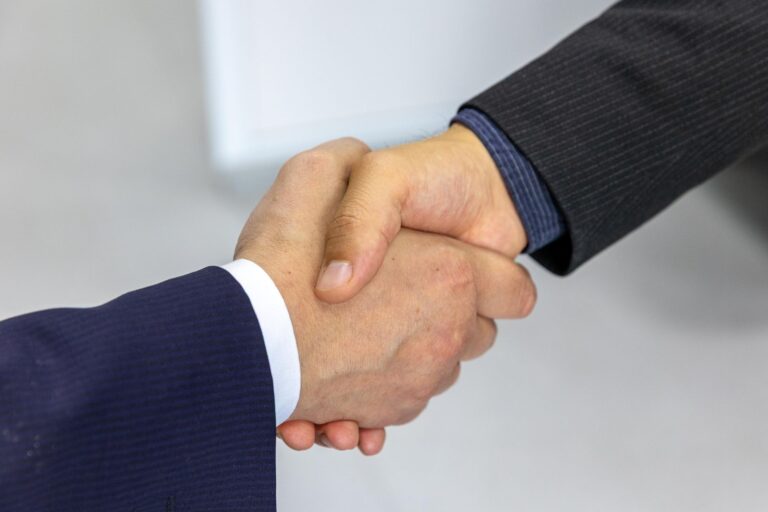 Two business people shaking hands, representing choosing a Google Ads agency