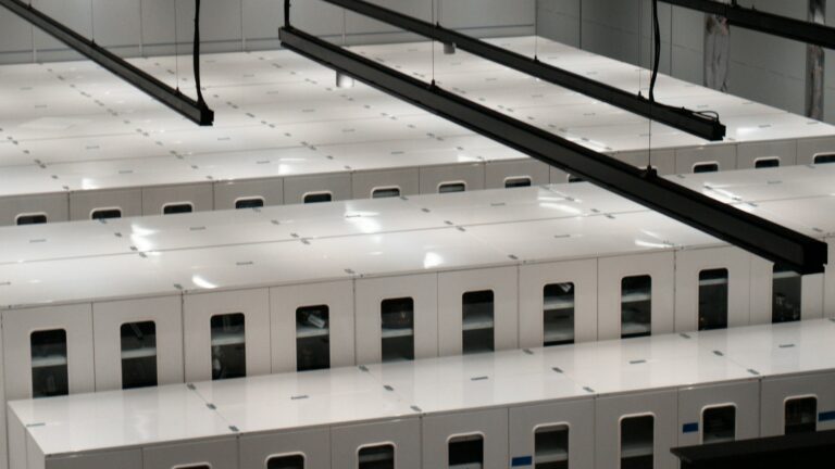 Rows of server cabinets in a data center, representing the infrastructure AI crawlers request when they read a website root file like llms.txt